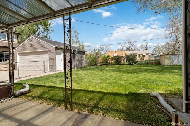 view of yard featuring fence, an outdoor structure, and a garage