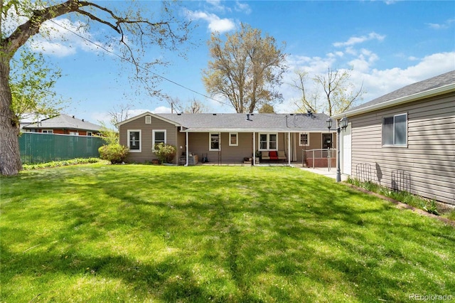 back of house featuring fence and a yard