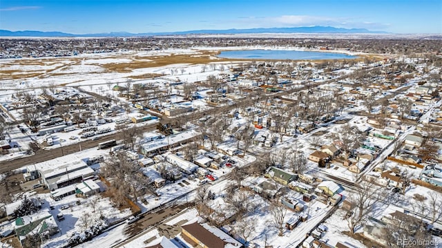 snowy aerial view with a water and mountain view