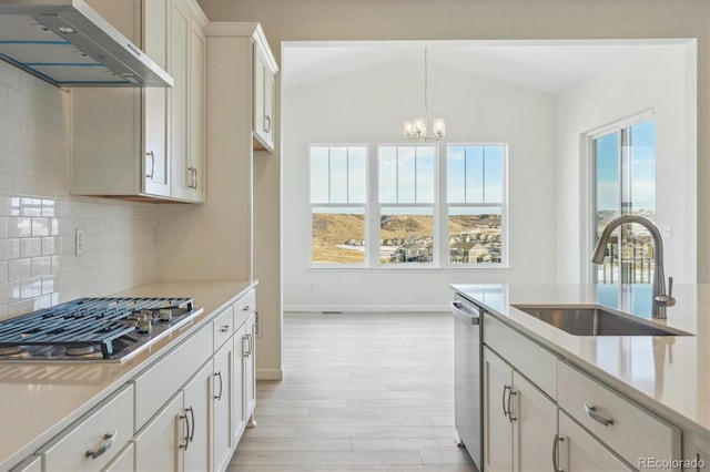 kitchen with a wealth of natural light, white cabinetry, stainless steel appliances, and range hood