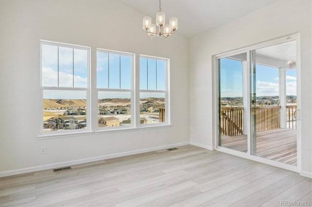 unfurnished dining area with light hardwood / wood-style floors and a chandelier