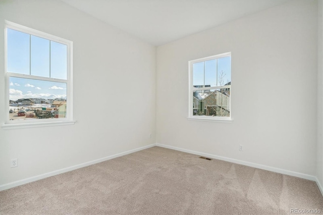 spare room featuring light colored carpet