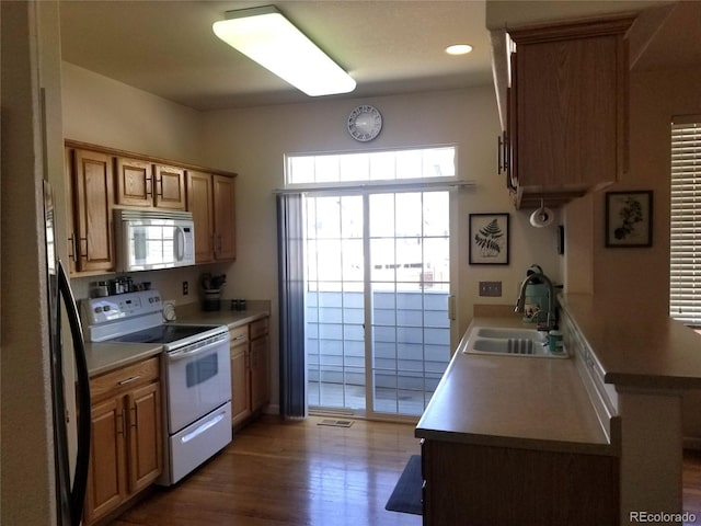 2240 S Pagosa Ct Unit B, Aurora, CO 80013 - kitchen featuring white appliances, a sink, wood finished floors, light countertops, and recessed lighting