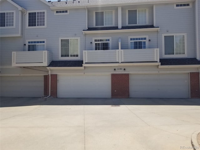 2240 S Pagosa Ct Unit B, Aurora, CO 80013 - rear view of property featuring brick siding, a garage, and concrete driveway