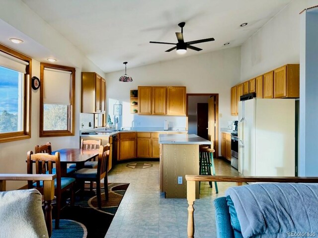 kitchen featuring pendant lighting, dishwasher, lofted ceiling, white refrigerator, and a kitchen island