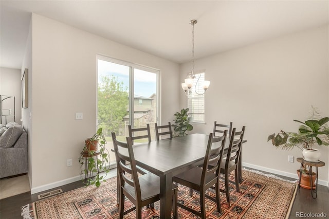 dining space featuring a notable chandelier and dark hardwood / wood-style floors