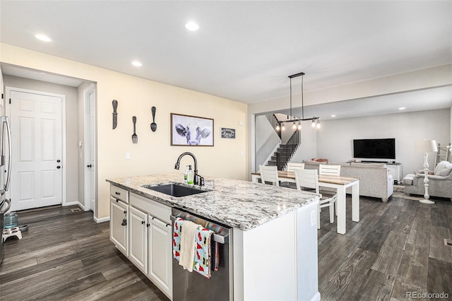 kitchen featuring sink, dishwasher, hanging light fixtures, an island with sink, and white cabinets