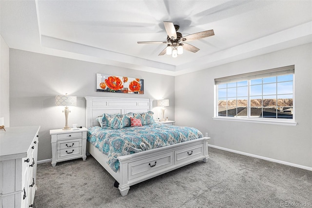 bedroom featuring a raised ceiling, carpet, and ceiling fan