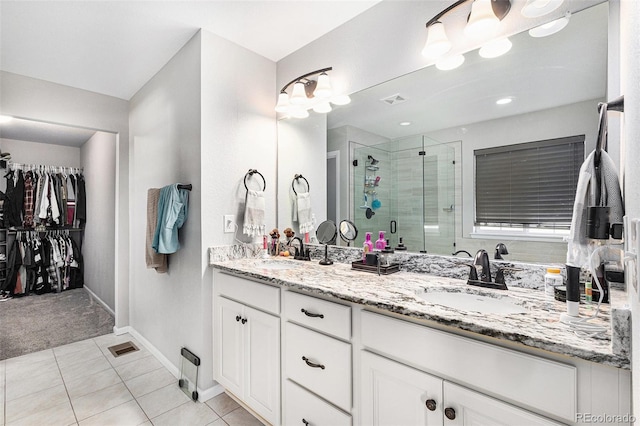 bathroom featuring tile patterned flooring, vanity, and walk in shower