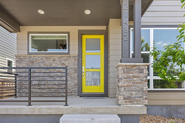21482 E 60th Ave, Aurora, CO 80019 - view of exterior entry featuring stone siding and a porch