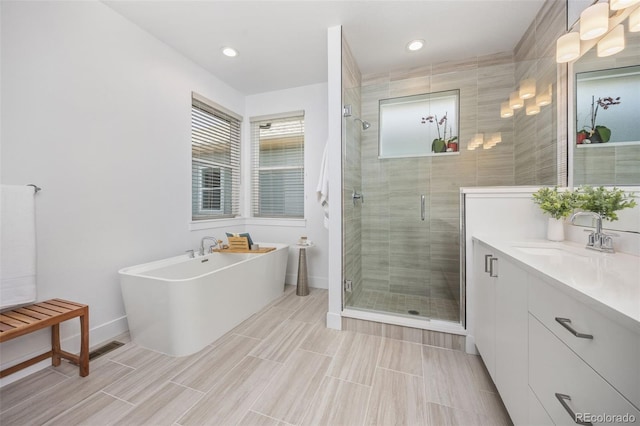 21482 E 60th Ave, Aurora, CO 80019 - full bath with vanity, a shower stall, a freestanding bath, baseboards, and recessed lighting