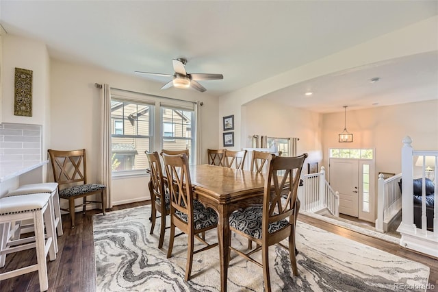 dining space with a ceiling fan, baseboards, and wood finished floors
