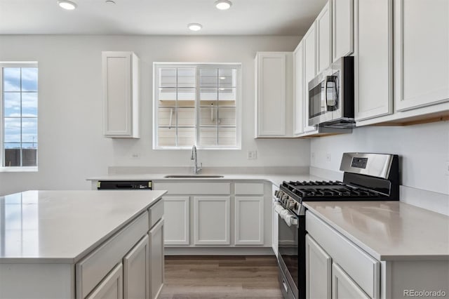 19100 E 96th Pl, Commerce City, CO 80022 - kitchen with appliances with stainless steel finishes, a sink, light countertops, recessed lighting, and wood finished floors