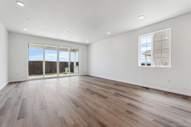 19100 E 96th Pl, Commerce City, CO 80022 - unfurnished room featuring healthy amount of natural light, wood finished floors, baseboards, and recessed lighting