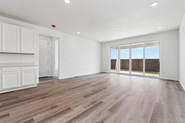 19100 E 96th Pl, Commerce City, CO 80022 - unfurnished living room with light wood finished floors, recessed lighting, and baseboards