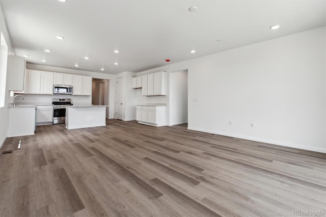 19100 E 96th Pl, Commerce City, CO 80022 - unfurnished living room featuring a sink, light wood-style flooring, recessed lighting, and baseboards