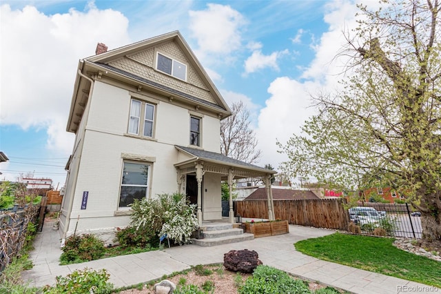 2719 W 32nd Ave, Denver, CO 80211 - victorian house featuring a chimney, brick siding, and a porch
