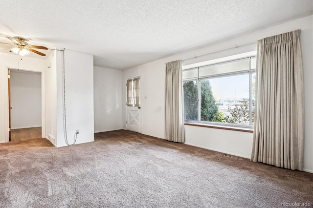 unfurnished room with ceiling fan, a textured ceiling, and carpet flooring