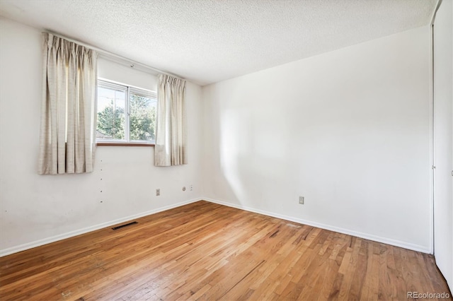 empty room featuring hardwood / wood-style floors and a textured ceiling