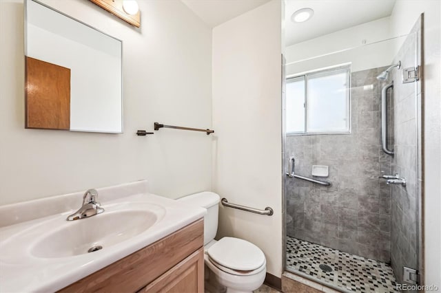 bathroom featuring vanity, toilet, and a shower with shower door