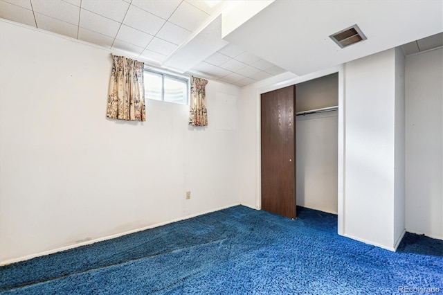 unfurnished bedroom featuring a closet and dark carpet