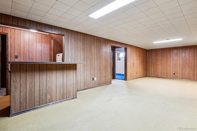 basement with light colored carpet and wooden walls