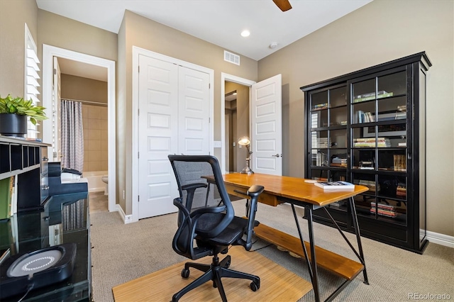 carpeted office space with ceiling fan