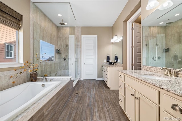 bathroom featuring independent shower and bath, vanity, and hardwood / wood-style floors