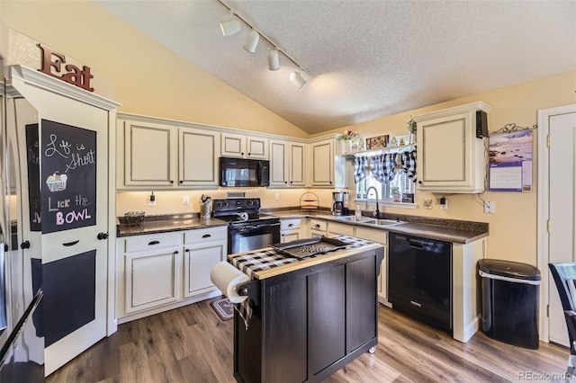 2251 W 135th Pl, Denver, CO 80234 - kitchen with black appliances, dark countertops, wood finished floors, track lighting, and a textured ceiling