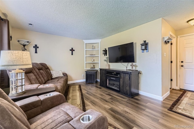 2251 W 135th Pl, Denver, CO 80234 - living area with wood finished floors, a textured ceiling, and built in features