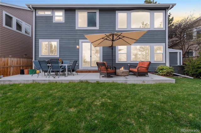rear view of house with a lawn, fence, and a patio area
