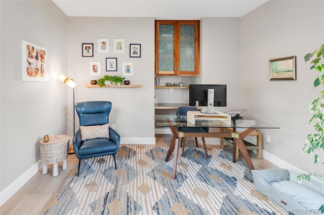 office area with baseboards and wood finished floors