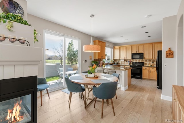dining space with light wood-type flooring and recessed lighting