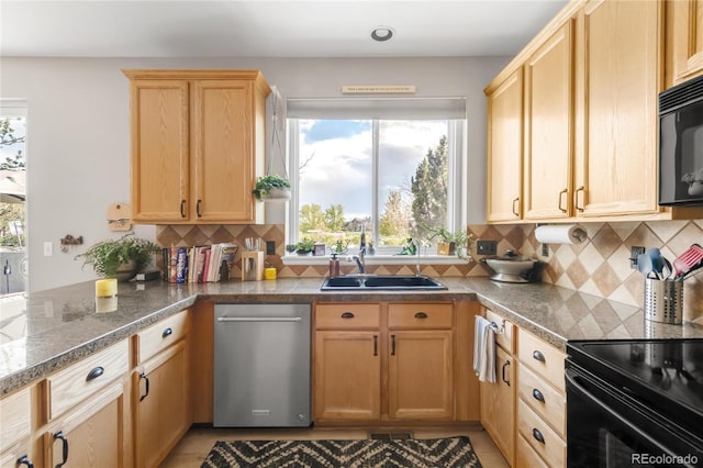 kitchen with a sink, light brown cabinetry, black appliances, and a healthy amount of sunlight