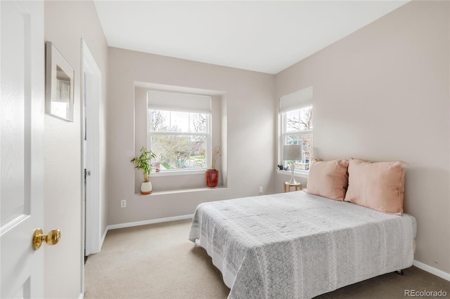 bedroom featuring light colored carpet and baseboards