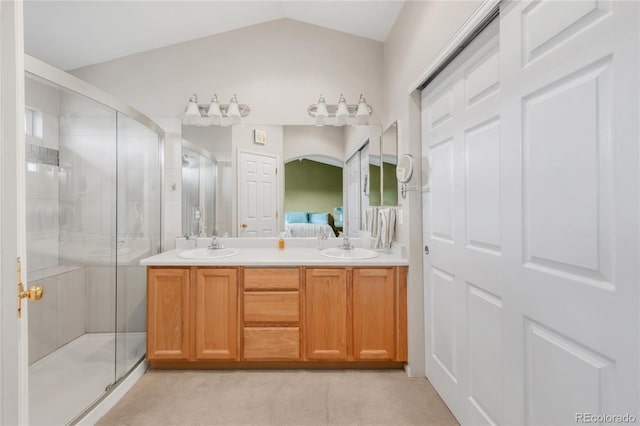 ensuite bathroom with double vanity, a shower stall, a sink, and connected bathroom