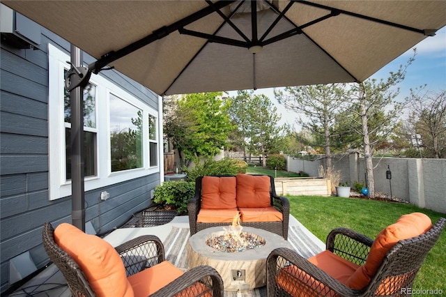view of patio / terrace with a fenced backyard and an outdoor living space with a fire pit