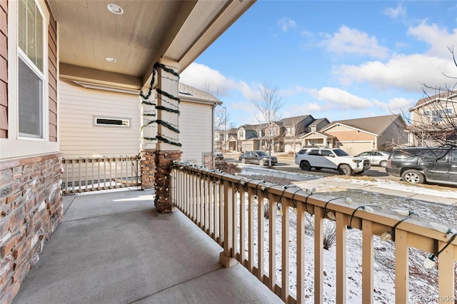 snow covered back of property with a porch