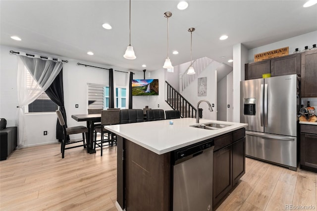 kitchen with sink, dark brown cabinetry, a center island with sink, and stainless steel appliances