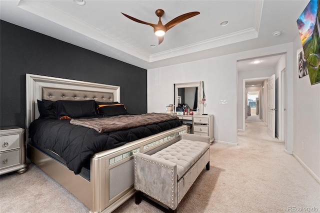 carpeted bedroom with ceiling fan and a raised ceiling