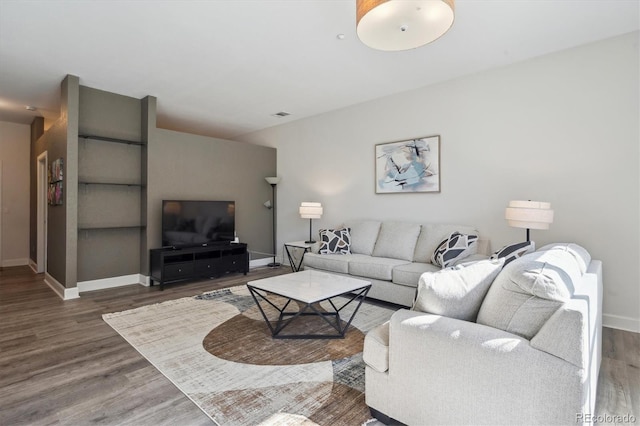 living area with baseboards and wood finished floors