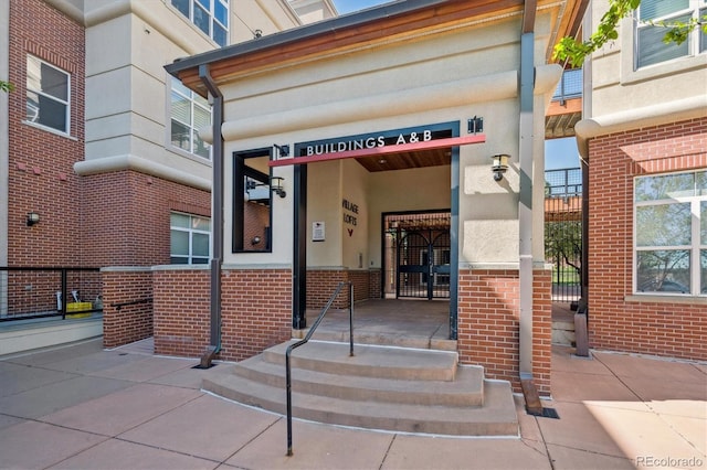 property entrance featuring stucco siding and brick siding