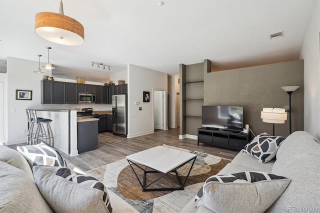 living area with light wood finished floors, baseboards, and lofted ceiling