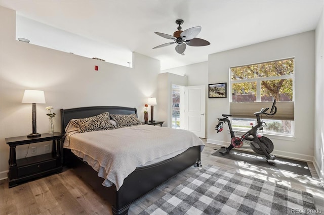 bedroom with baseboards, wood finished floors, and ceiling fan