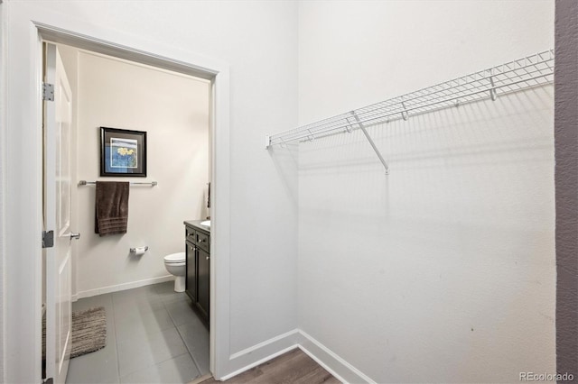 walk in closet with dark tile patterned floors