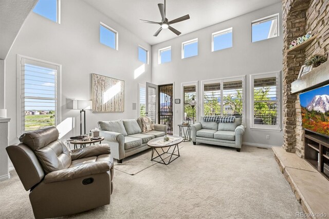 2373 S Joyce St, Denver, CO 80228 - carpeted living area featuring ceiling fan, a fireplace, a towering ceiling, and baseboards