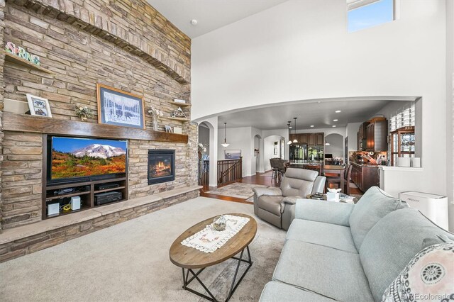 2373 S Joyce St, Denver, CO 80228 - living room with arched walkways, a high ceiling, a fireplace, and carpet floors