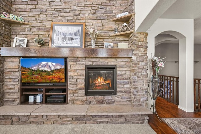 2373 S Joyce St, Denver, CO 80228 - living room featuring wood finished floors, baseboards, arched walkways, and a fireplace