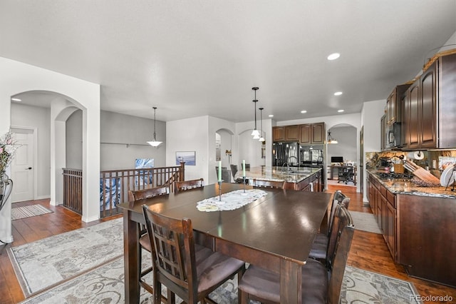 2373 S Joyce St, Denver, CO 80228 - dining area with arched walkways, wood finished floors, recessed lighting, and baseboards