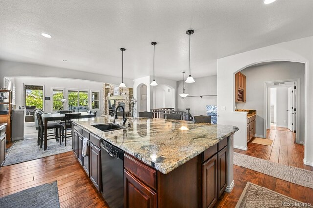 2373 S Joyce St, Denver, CO 80228 - kitchen with black dishwasher, a sink, arched walkways, dark wood-style floors, and recessed lighting